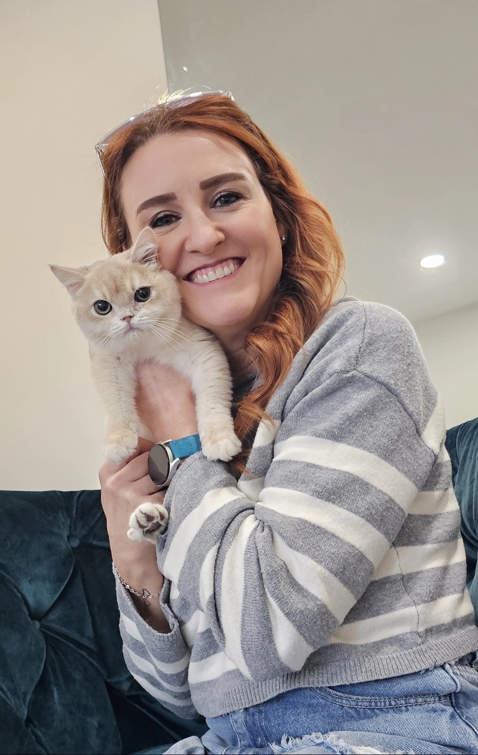 Dr. Rene' smiling while holding a cream-colored kitten